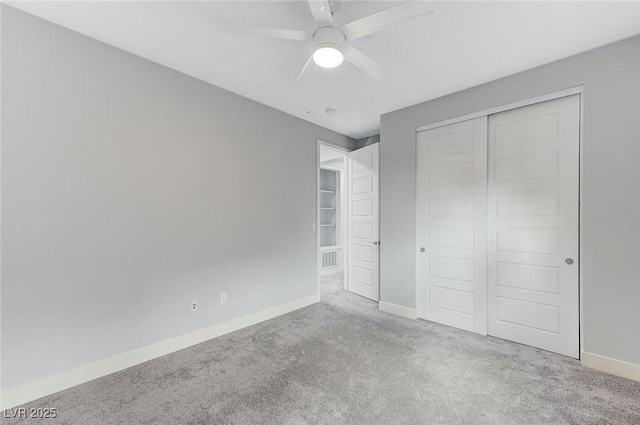 unfurnished bedroom featuring ceiling fan, a closet, and light carpet