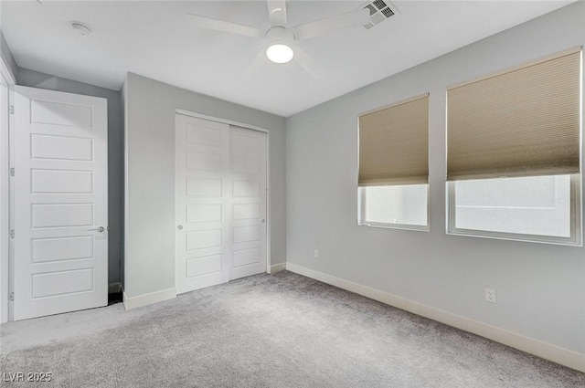 unfurnished bedroom with ceiling fan, a closet, and light carpet