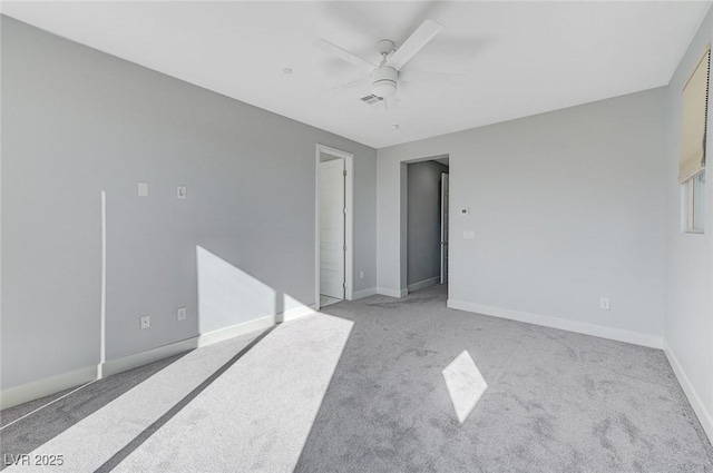 empty room with ceiling fan, baseboards, and light colored carpet