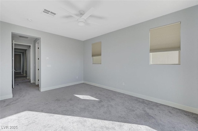 empty room featuring a ceiling fan, carpet flooring, visible vents, and baseboards