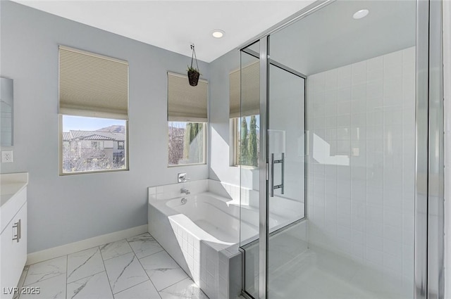 bathroom featuring marble finish floor, a garden tub, vanity, a shower stall, and baseboards