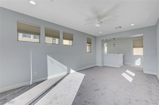 spare room featuring ceiling fan and light carpet