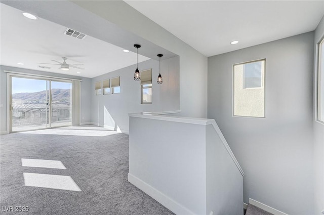 bar with carpet floors, ceiling fan, a mountain view, and pendant lighting