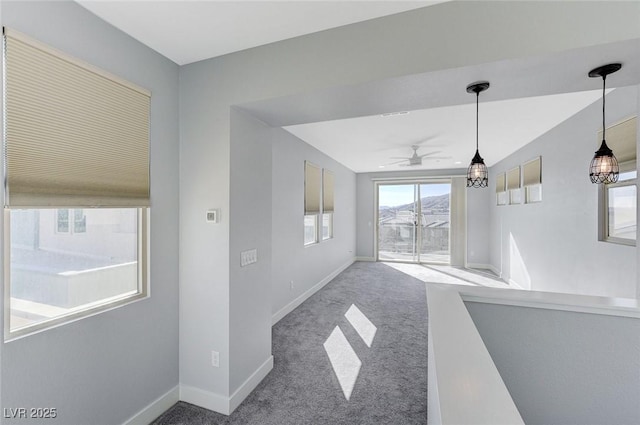 interior space featuring ceiling fan, carpet, and baseboards