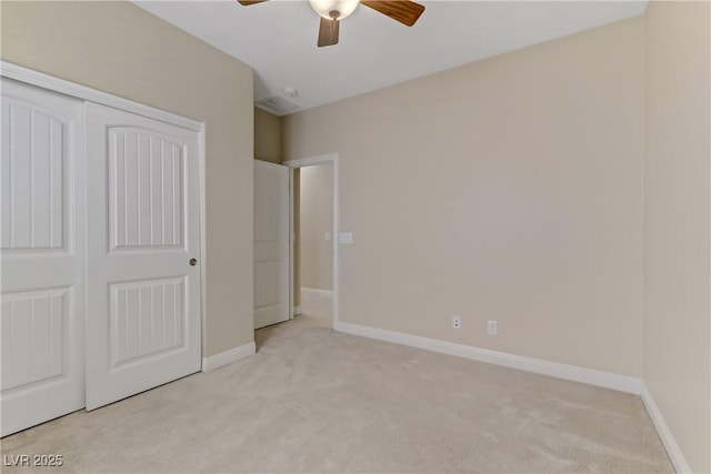 unfurnished bedroom featuring light carpet, a closet, and ceiling fan