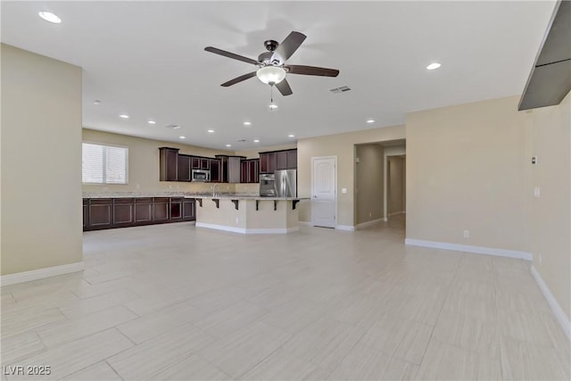 unfurnished living room with ceiling fan and light tile patterned flooring