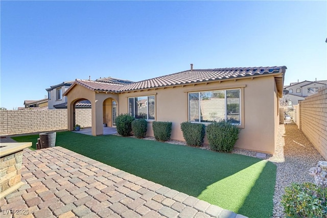 back of house with a lawn and a patio area