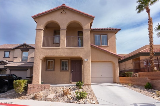 view of front of house featuring a tiled roof, an attached garage, and stucco siding