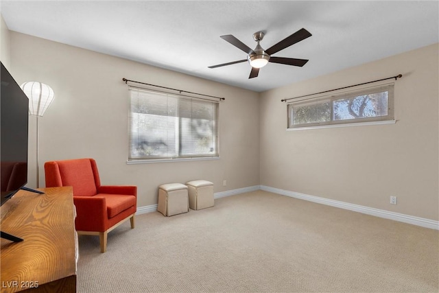 sitting room with ceiling fan and light colored carpet