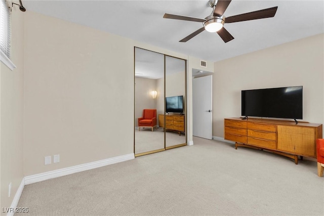 bedroom featuring ceiling fan, a closet, and light carpet