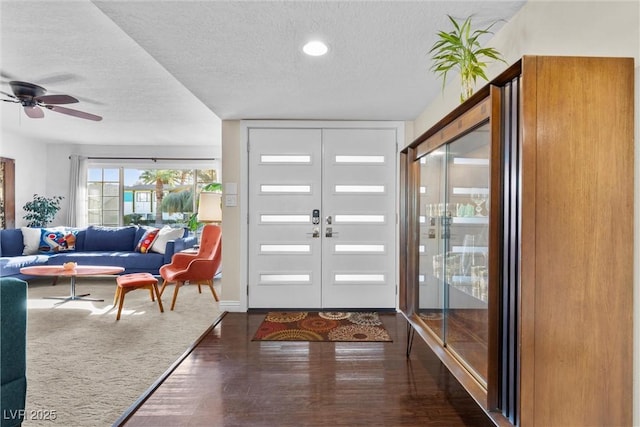 entrance foyer featuring a textured ceiling, dark wood-type flooring, french doors, and ceiling fan