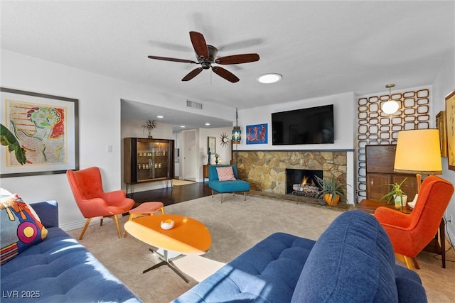 living room featuring ceiling fan and a fireplace