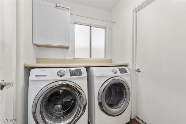 clothes washing area with cabinets and separate washer and dryer