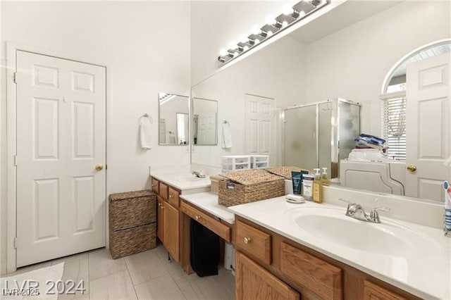 bathroom with a shower with shower door, tile patterned floors, vanity, and washer / clothes dryer