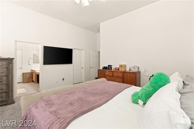 carpeted bedroom with ceiling fan and ensuite bath