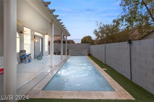 view of swimming pool featuring ceiling fan and a patio