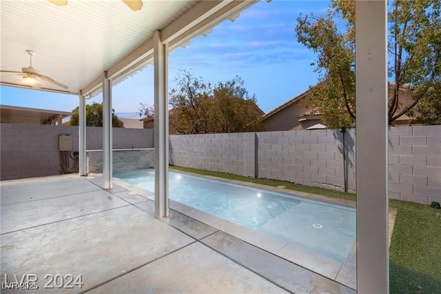 view of swimming pool featuring ceiling fan and a patio area