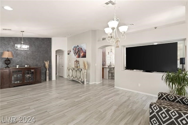 living room featuring a chandelier and light wood-type flooring