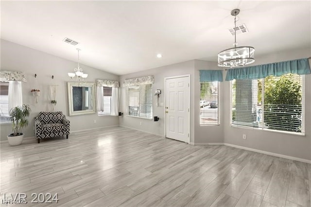 foyer entrance featuring lofted ceiling and a chandelier