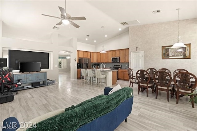 living room with high vaulted ceiling, sink, and ceiling fan