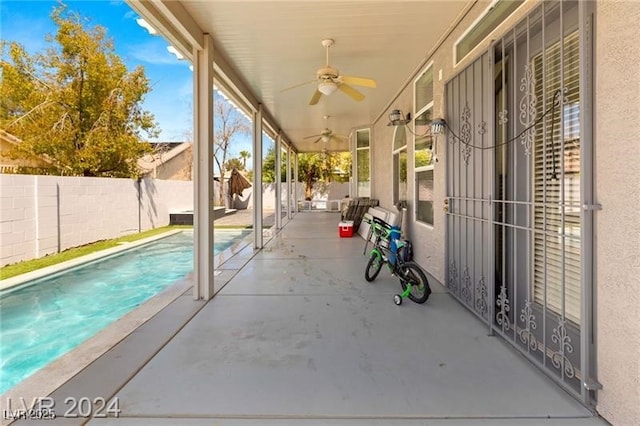 view of swimming pool featuring ceiling fan and a patio area