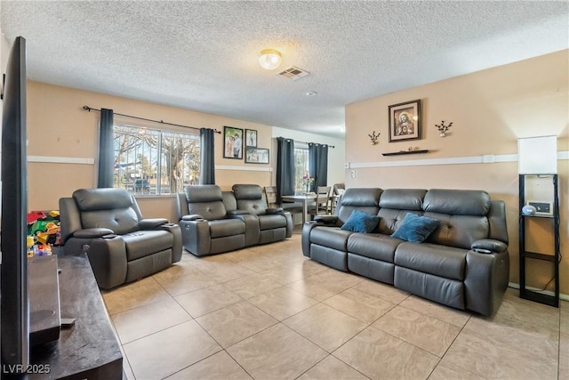 living room featuring light tile patterned floors, plenty of natural light, and a textured ceiling