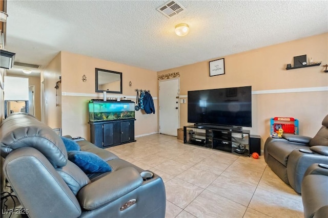 living room with a textured ceiling and light tile patterned floors