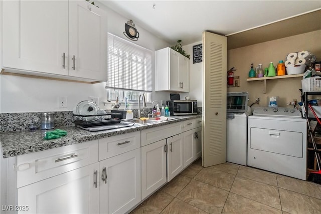 laundry room featuring sink, light tile patterned floors, and washer / clothes dryer