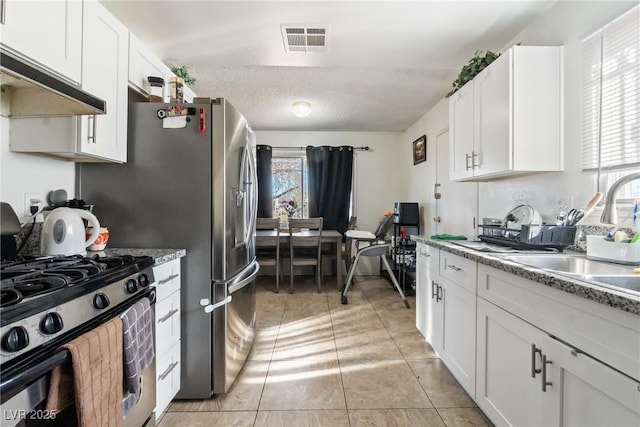 kitchen featuring sink, white cabinetry, a textured ceiling, light tile patterned floors, and gas range