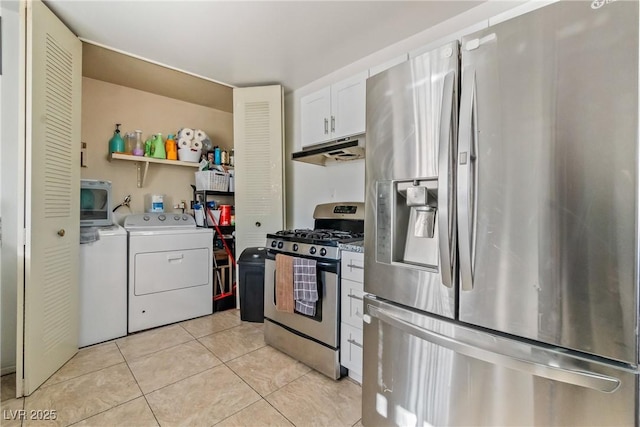 kitchen featuring light tile patterned floors, appliances with stainless steel finishes, white cabinetry, and washer and dryer