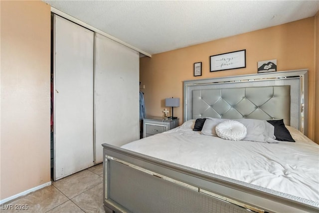 tiled bedroom featuring a textured ceiling and a closet