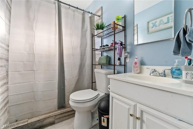 bathroom featuring toilet, walk in shower, and vanity