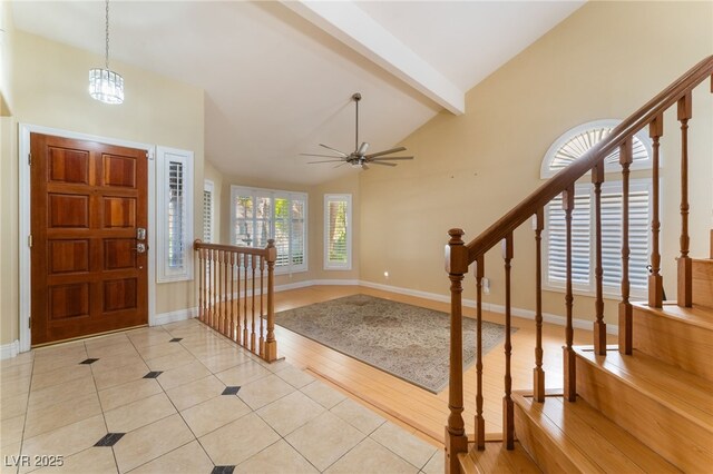 foyer with ceiling fan, vaulted ceiling with beams, and light tile patterned flooring