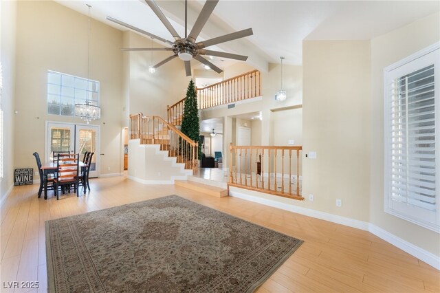 interior space with high vaulted ceiling, ceiling fan, and hardwood / wood-style flooring