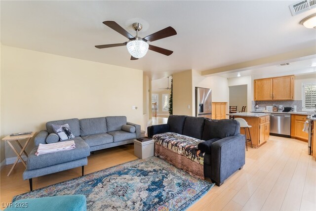 living room featuring ceiling fan and light hardwood / wood-style floors