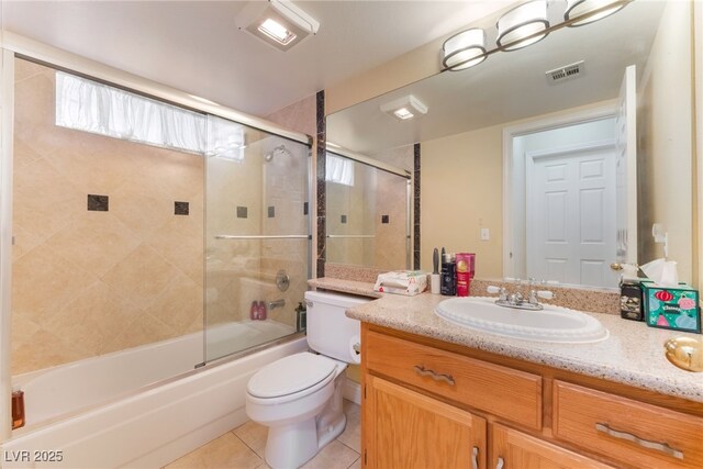 full bathroom featuring toilet, vanity, tile patterned flooring, and shower / bath combination with glass door