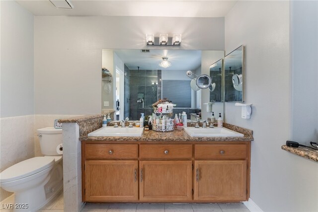 bathroom featuring toilet, tile patterned floors, walk in shower, and vanity