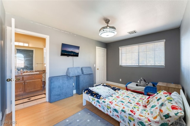 bedroom featuring light hardwood / wood-style floors and ensuite bathroom