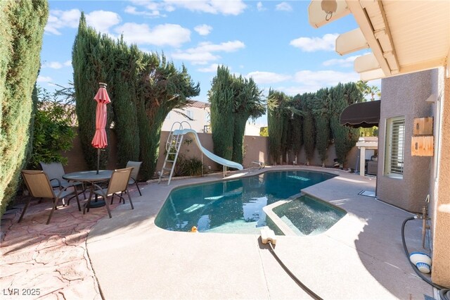 view of swimming pool with a patio area and a water slide