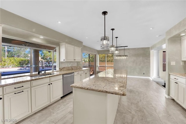 kitchen featuring decorative columns, a kitchen island, pendant lighting, stainless steel dishwasher, and sink