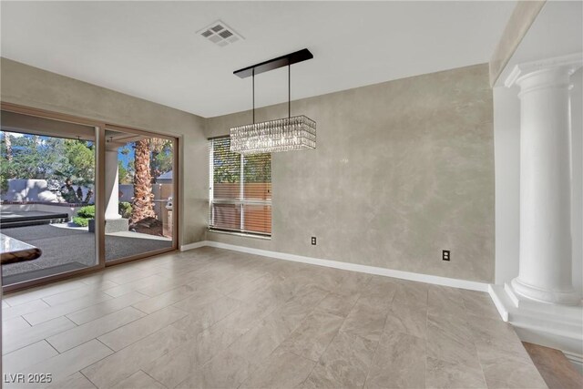 unfurnished dining area with a chandelier and decorative columns