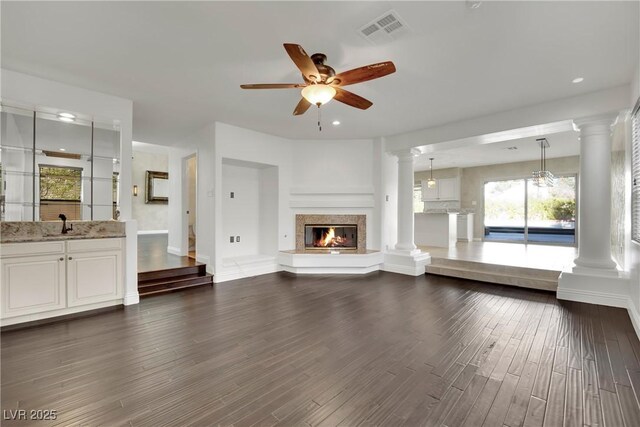 unfurnished living room with ceiling fan and dark wood-type flooring