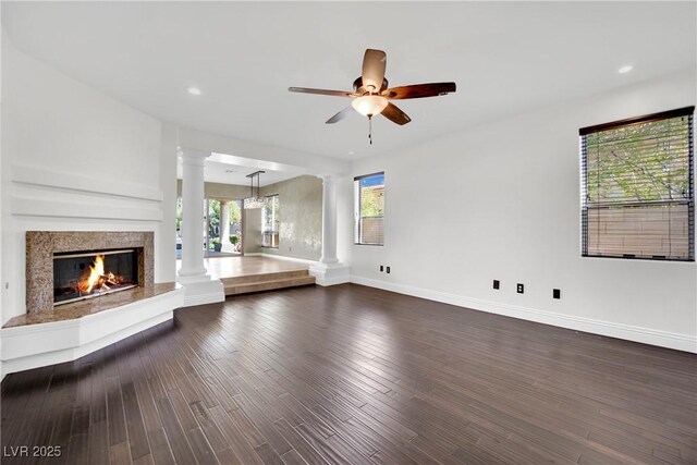 unfurnished living room featuring ceiling fan and dark hardwood / wood-style floors