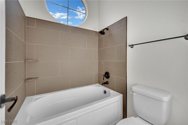 bathroom with toilet and tiled shower / bath