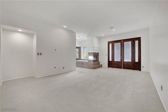 unfurnished living room featuring light colored carpet and a fireplace