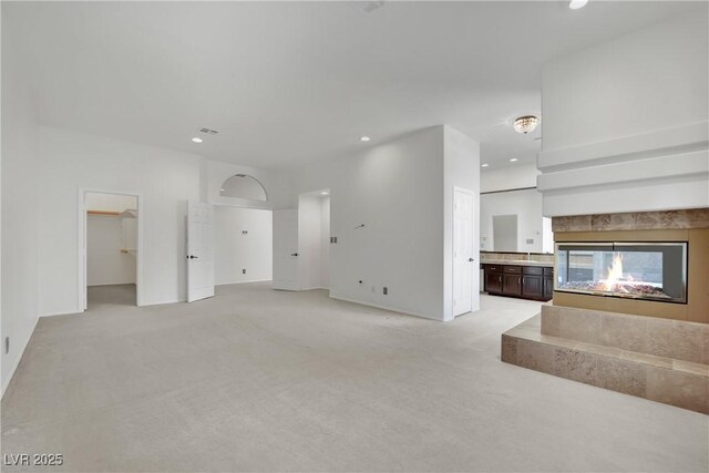 unfurnished living room featuring light colored carpet