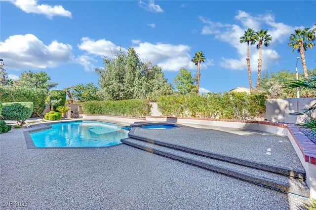 view of swimming pool featuring an in ground hot tub