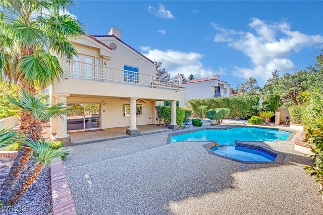 view of swimming pool featuring a patio area and an in ground hot tub