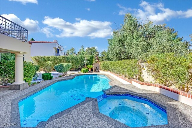 view of swimming pool with an in ground hot tub