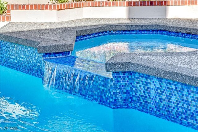 view of swimming pool featuring a jacuzzi